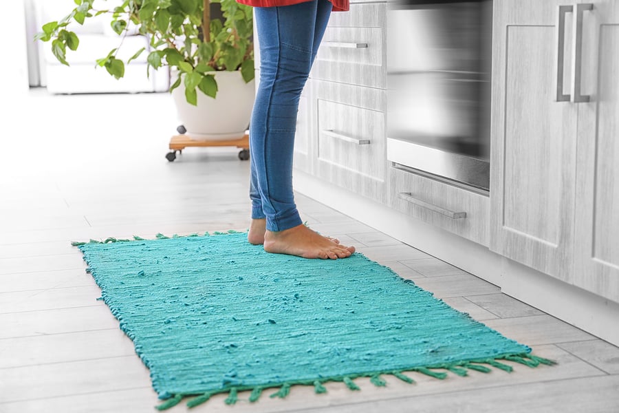 Make Your Kitchen More Inviting With A Cozy Floor Runner   Bigstock Woman Standing On Rug In Kitch 223351330 